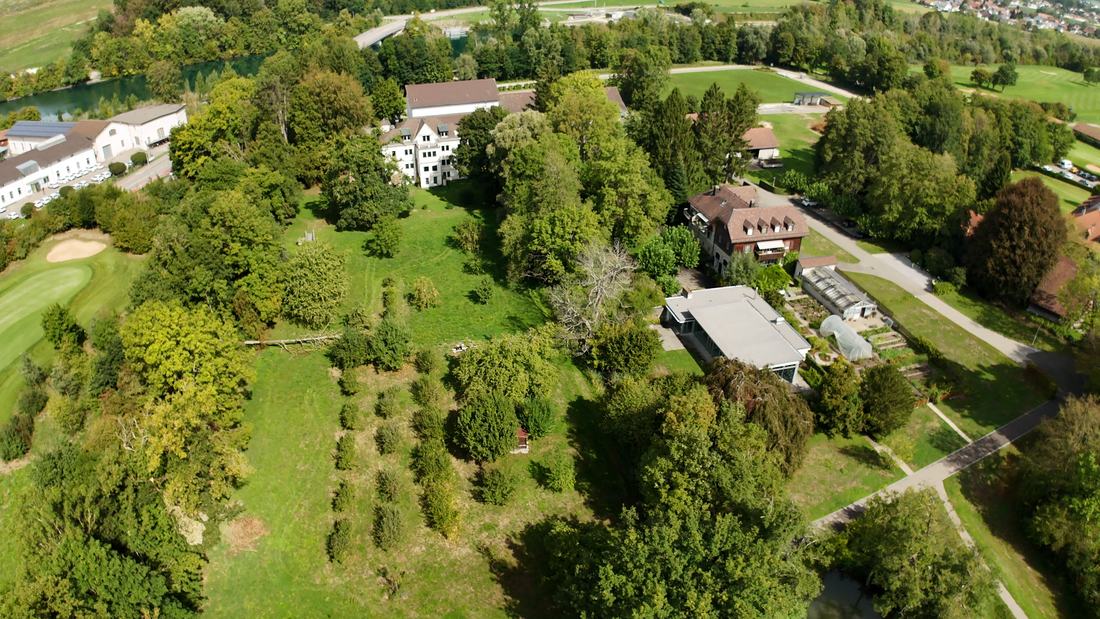 The western part of the estate: orchards and meadows, the kitchen garden with its glasshouses, the garden buildings — beyond them the Aare and the fairways